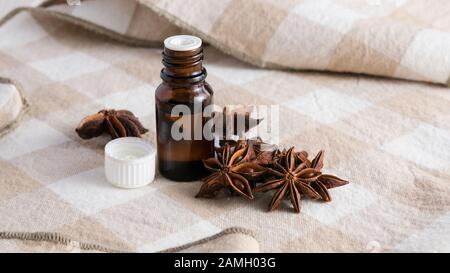 Kosmetische Zusammensetzung, Anis und eine Glasflasche mit ätherischen Öl auf dem Tisch Stockfoto