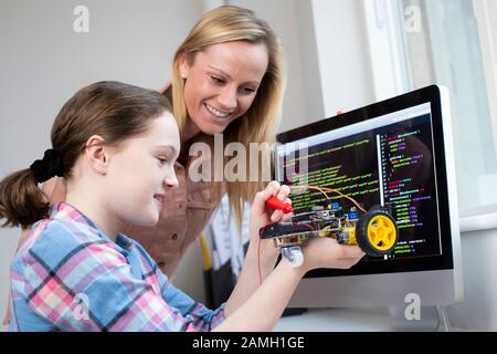 Lehrer Hilft Weiblichen Schülern Beim Bau Von Roboterwagen In Der Lektion "Wissenschaft" Stockfoto