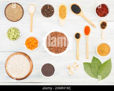 Zutaten zum Kochen von Reis: Salz, Allwürze, Kreuzkümmel (jeera), Chili, Zwiebel, Masala, Lorbeerblätter, Knoblauch, Senfkörner, Karotte, Fenugreek, Kardamom, Klo Stockfoto