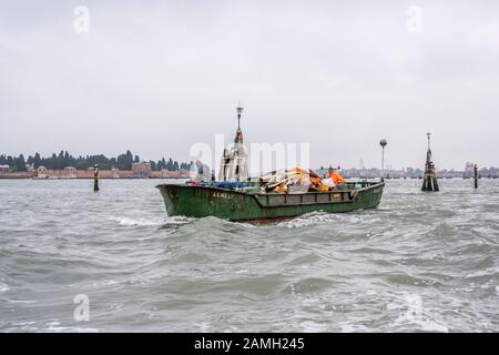 Venedig, ITALIEN - 29. Oktober 2019: Kahn für Müllabfuhr Segel vor dem inselfriedhof san Michele, am 29. oktober 2019 bei strahlendem Wetter erschossen Stockfoto