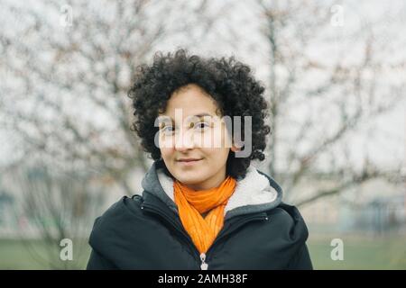 Junge selbstbewusste Frau porträtiert draußen. Analoger Filmlook. Authentisches, milleniales Konzept für junge Mädchen. Stockfoto