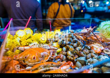 Bangkok/Thailand-05 Dezember 2019: Szenen aus dem Talat Rot Fai Nachtlebensmittelmarkt, mit verschiedenen Artikeln von Meeresfrüchten, die auf Eis liegen, sind zum Verkauf bereit. Stockfoto