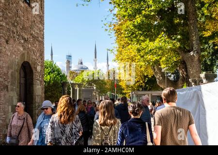 Die Touristenmassen passieren das Äußere des Hagia Sophia Museums mit der Blauen Moschee im Blick dahinter im Viertel Sultanahmet von Istanbul. Stockfoto