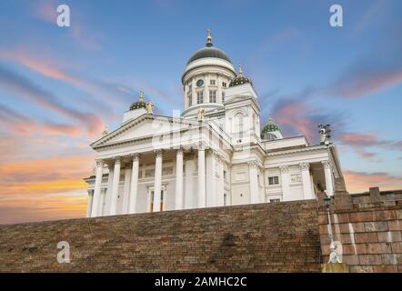 Die neoklassizistische Kathedrale von Helsinki und die Stufen, die vom Senatsplatz unter einem farbenfrohen Sonnenuntergang in Helsinki, Finnland, zu ihr hinaufführen. Stockfoto