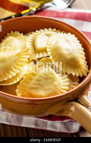 Italienische Teigwaren. Panzerotti-Pasta in der Schüssel auf dem alten Küchentisch. Stockfoto