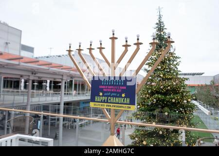 Großer Freiluftmenorah Chanukah (Hanukkah), platziert von der jüdischen Organisation Chabad, auf der City Center Bishop Ranch in San Ramon, Kalifornien, mit Weihnachtsbaum im Hintergrund, 25. Dezember 2019. () Stockfoto