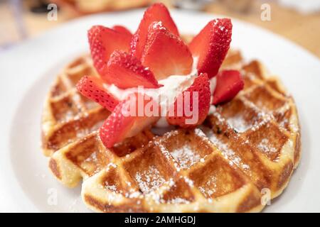 Nahaufnahme der belgischen Waffel mit Erdbeeren und Schlagsahne auf weißem Teller im Denica's Restaurant, Dublin, Kalifornien, 28. Dezember 2019. () Stockfoto