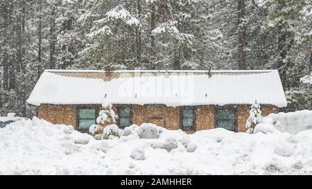 Ein farbenfrohes Haus, das in den Bergen, in der Sierra Nevada, Kalifornien, unter einem Schneesturm isoliert ist Stockfoto