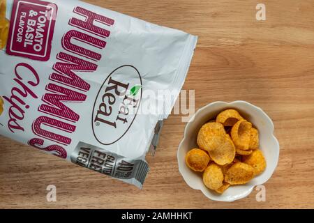 Packung Hummuschips Tomaten- und Basilikageschmack durch Essen Echt. Vegane und glutenfreie Snacks, Großbritannien. Stockfoto