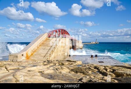 VALLETTA, MALTA. Dezember 2019. In den frühen Phasen eines Wintersturms stürzen Wellen in die Breakwater Bridge (St. Elmo Breakwater) in Valletta Gra Stockfoto