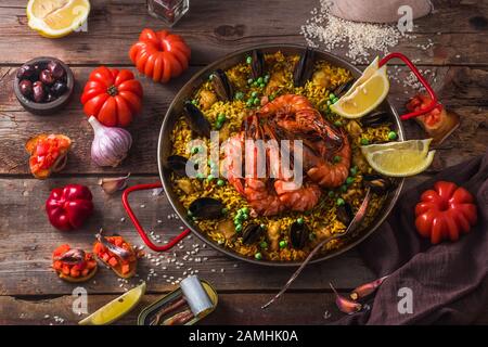 Köstliche Meeresfrüchte Paella mit Gemüse auf einem Tisch, rustikaler Stil Stockfoto