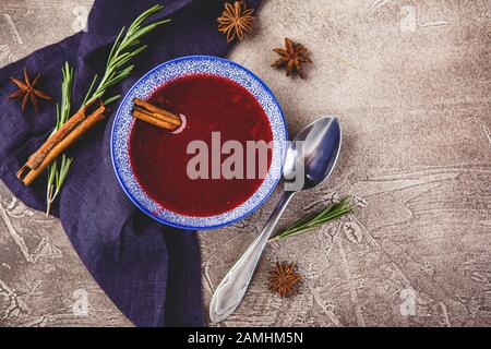 Hausgemachte würzige Süßsoße aus nördlichen Waldbeeren Preiselbeeren und Äpfeln mit Rosmarin, Zimt und Anissternen in blauer Schüssel. Draufsicht. Platz Stockfoto