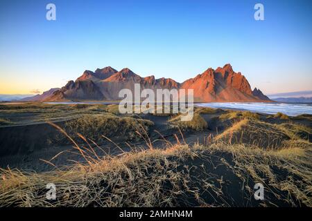 Vestrahorn Bergkette in Stokksnes, dem südlichen Kap von Island. Gipfel, die 454 m hoch sind und von schwarzen vulkanischen Sanddünen umgeben sind. Stockfoto