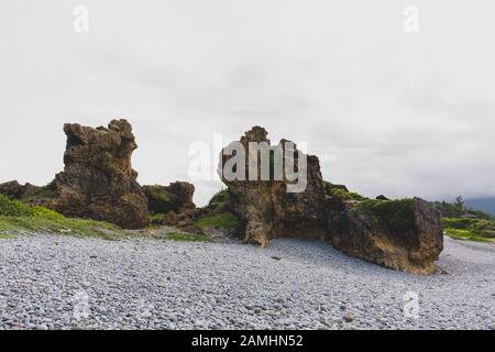 Blick auf einzigartige Felsformationen und Kieselsteine am Strand in der Nähe der Sansiantai Arch Bridge, Chenggong Township, Taitung County, Taiwan Stockfoto