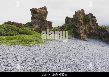 Blick auf einzigartige Felsformationen und Kieselsteine am Strand in der Nähe der Sansiantai Arch Bridge, Chenggong Township, Taitung County, Taiwan Stockfoto