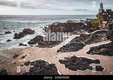 Die natürlichen Pools von El Caleton Garachico in einem Vulkanausbruch mit San Miguel Schloss im Hintergrund erstellt werden. Stockfoto