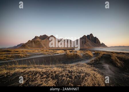 Vestrahorn Bergkette in Stokksnes, dem südlichen Kap von Island. Gipfel, die 454 m hoch sind und von schwarzen vulkanischen Sanddünen umgeben sind. Stockfoto