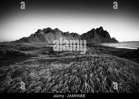 Vestrahorn Bergkette in Stokksnes, dem südlichen Kap von Island. Gipfel, die 454 m hoch sind und von schwarzen vulkanischen Sanddünen umgeben sind. Stockfoto