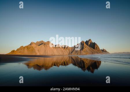 Vestrahorn Bergkette in Stokksnes, dem südlichen Kap von Island. Gipfel, die 454 m hoch sind und von schwarzen vulkanischen Sanddünen umgeben sind. Stockfoto