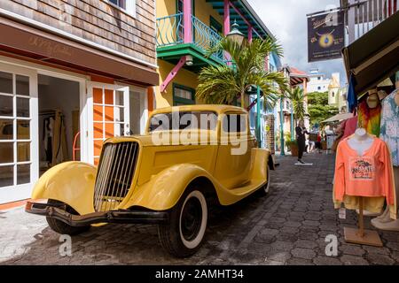 Ein gelber Oldtimer an Der Old Street in Philipsburg, Sint Maarten, St. Maarten, Niederländische Antillen, Westindien, Karibik. Stockfoto