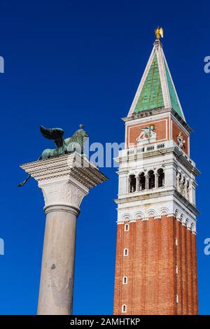 Skulptur des geflügelten Löwen von Venedig auf einer Säule mit dem Markuspanile, dem Markusplatz, Venedig, Venetien, Italien, Europa Stockfoto