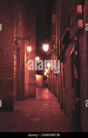 Eine traditionelle, alte schmale Straße leuchtete nachts mit altmodischen Straßenlaternen Stockfoto