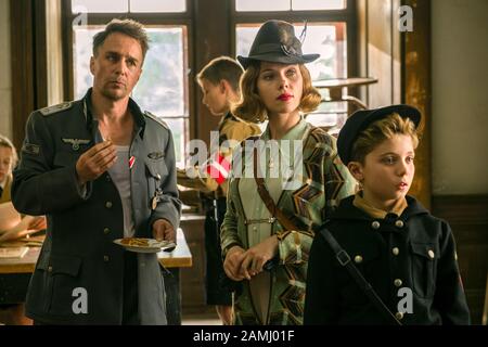 Jojo Rabbit (2019) von Taika Waititi mit Sam Rockwell als Captain Klenzendorf, Scarlett Johansson als Rosie Betzler und Roman Griffin Davis als Johannes „Jojo Rabbit“ Betzler. Komödie nach Christine Leunens Roman über die Hitlerjugend. Werbefoto ***NUR REDAKTIONELLE VERWENDUNG***. Beschreibung: BFA / Larry Horricks / Fox Searchlight Pictures Stockfoto