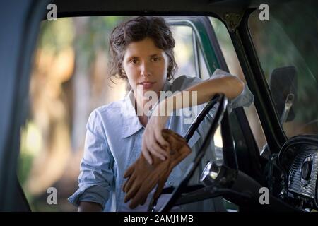 Vorderansicht einer jungen Frau in der Nähe eines Autos. Stockfoto