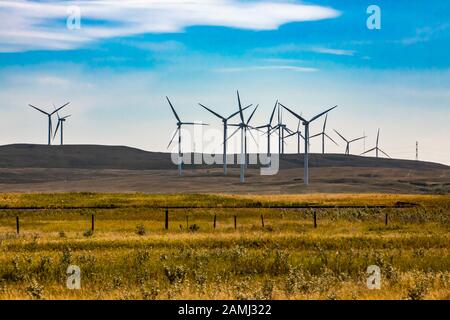 Ein Weitwinkelschuss von sanften Hügeln mit einem Windpark im ländlichen Saskatchewan, Kanada. Natürliche, erneuerbare und nachhaltige Energiewirtschaft mit Kopierfläche Stockfoto