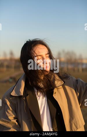 Schönes Mädchen im Regenmantel im Freien. Stockfoto