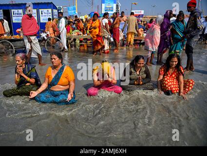 Hindu-Frauen-Pilger nehmen während des Makar-Sankranti-Übergangs ein heiliges Bad in Gangasagar wie im Ritual. Gangasagar ist einer der religiösen Stätten für die Hindu-Pilger an der Bucht von Bengalen, wo jedes Jahr Millionen von Gläubigen während des Makar Sankranti (Übergang der Sonne) nach hinduistischem Kalender ein heiliges Bad nehmen und dem Kapil Muni-Tempel gebeten werden. Der Termin für dieses Festival liegt normalerweise zwischen dem 13. Und 15. Januar des Jahres. Stockfoto