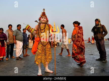 Ein Anhänger, der sich nach hinduistischer Mythologie wie Lord Shiva verkleidet hat, während des Gangasagar-Festivals, um einige Opfergaben von den Pilgern zu erhalten.Gangasagar ist einer der religiösen Stätten für die Hindu-Pilger, die an der Bucht von Bengalen aufgestellt sind, wo jedes Jahr Millionen von Gläubigen ein heiliges Bad nehmen Während Makar Sankranti (Übergang der Sonne) gemäß Hindu-Kalender und bieten gebeten zum Kapil Muni Tempel. Der Termin für dieses Festival liegt normalerweise zwischen dem 13. Und 15. Januar des Jahres. Stockfoto