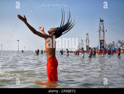 Ein indischer Sadhu nimmt ein heiliges Bad während des Gangasagar-Festivalgangasagar ist einer der religiösen Stätten für die Hindu-Pilger an der Bucht von Bengalen, wo jedes Jahr Millionen von Gläubigen während Makar Sankranti (Übergang der Sonne) ein heiliges Bad nehmen. Nach hinduistischem Kalender, und bitten Sie den Kapil Muni Tempel. Der Termin für dieses Festival liegt normalerweise zwischen dem 13. Und 15. Januar des Jahres. Stockfoto