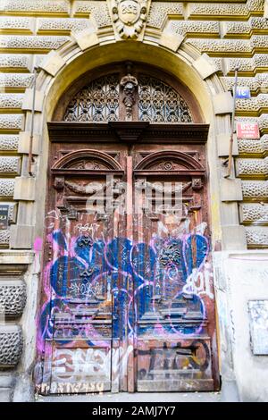 Graffiti auf einer alten, verzierten Holztür in Prag, Tschechien. Stockfoto