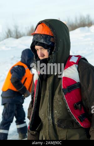 Arbeiter in einem orangefarbenen Helm mit einer Kapuze auf seinem Kopf Stockfoto