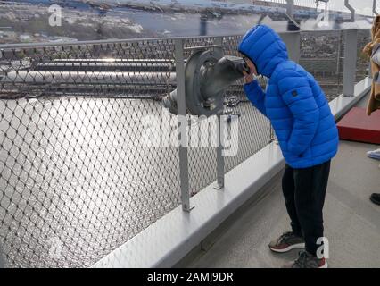 Ein kleines Kind blickt durch ein Teleskop auf die Aussichtsplattform von Adam Lookout, Amsterdam, Niederlande Stockfoto