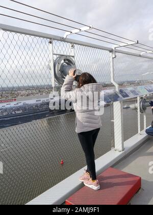 Ein kleines Kind blickt durch ein Teleskop auf die Aussichtsplattform von Adam Lookout, Amsterdam, Niederlande Stockfoto