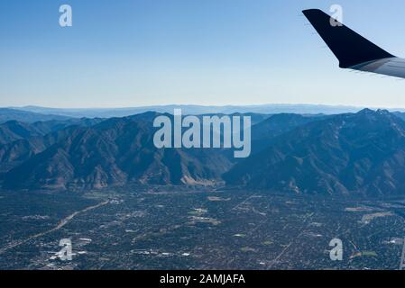 Blick auf die Witwensitze von Salt Lake City, Utah nach Houston, Texas Flug an einem Sommertag, der über Bergkette und Farmen fliegt. Stockfoto