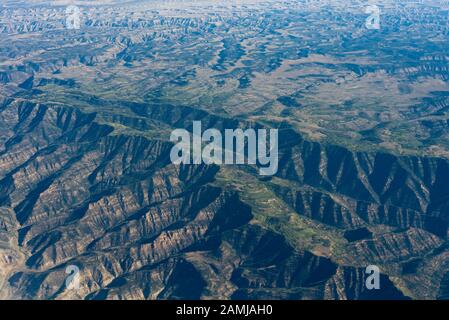 Blick auf die Witwensitze von Salt Lake City, Utah nach Houston, Texas Flug an einem Sommertag, der über Bergkette und Farmen fliegt. Stockfoto