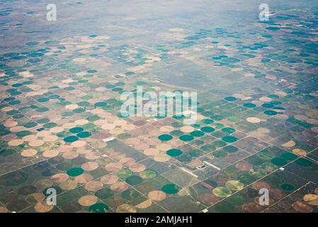 Blick auf die Witwensitze von Salt Lake City, Utah nach Houston, Texas Flug an einem Sommertag, der über Bergkette und Farmen fliegt. Stockfoto