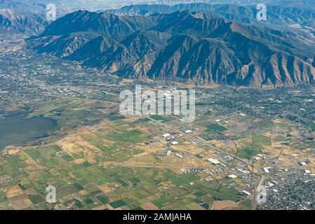 Blick auf die Witwensitze von Salt Lake City, Utah nach Houston, Texas Flug an einem Sommertag, der über Bergkette und Farmen fliegt. Stockfoto