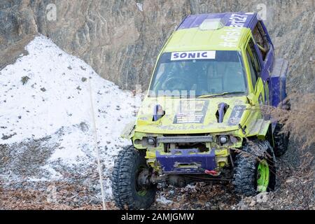 Jeep Suzuki Jimny überwindet Hindernisse in den Wald Stockfoto