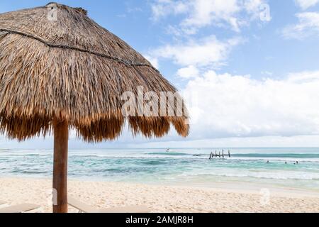 Nahaufnahme des Sonnenschirms aus Kokospalmblatt mit blauem Himmel und Kopierraum an einem Strand in Cancun in Mexiko. Stockfoto