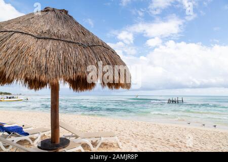 Nahaufnahme des Sonnenschirms aus Kokospalmblatt mit blauem Himmel und Kopierraum an einem Strand in Cancun in Mexiko. Stockfoto