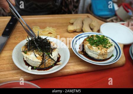 Frau, die Hausgemachte Agedashi Tofu mit Sojasoße kocht Stockfoto