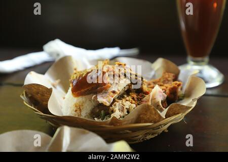 Nasi Campur babi guling. Balinesen Reis Gericht der Schweinebraten mit anderen Schweinefleisch und Gemüsebeilagen. Stockfoto