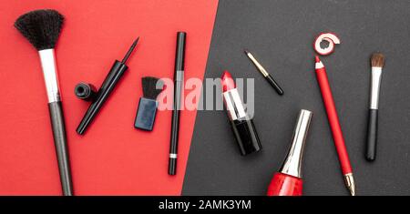 Kosmetikzubehör in rot und schwarz aufmachen. Lippenstift, nagelpoliermittel, Augenstift und Bürsten vor rotem und schwarzem Farbhintergrund Stockfoto