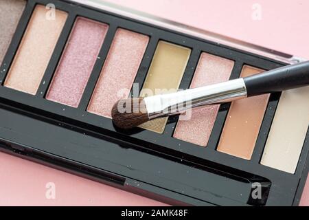 Eyesheatows pallete setzen Pastellfarben und bürsten vor pinkfarbenem Hintergrund, Nahaufnahme. Professionelle Werkzeuge für Make-up, Beauty-Salon, Kosmetikkonzept Stockfoto