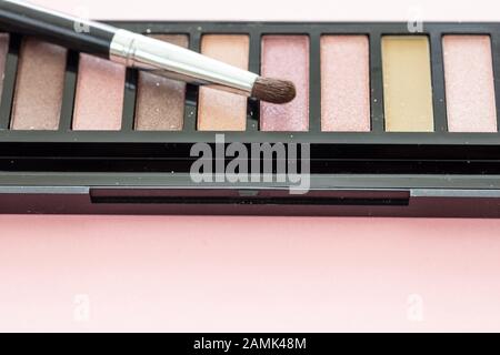 Augenschatten pallete setzen pastellbraune Farben und bürsten vor rosafarbenem Hintergrund, Nahaufnahme. Professionelle Werkzeuge für Make-up, Beauty-Salon, Kosmetik c Stockfoto