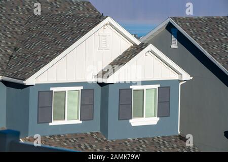 Grau-weiße Hausfassade mit Fensterläden Stockfoto